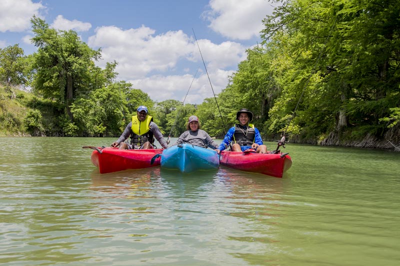 Leon, Leticia and their son sit atop kayaks.